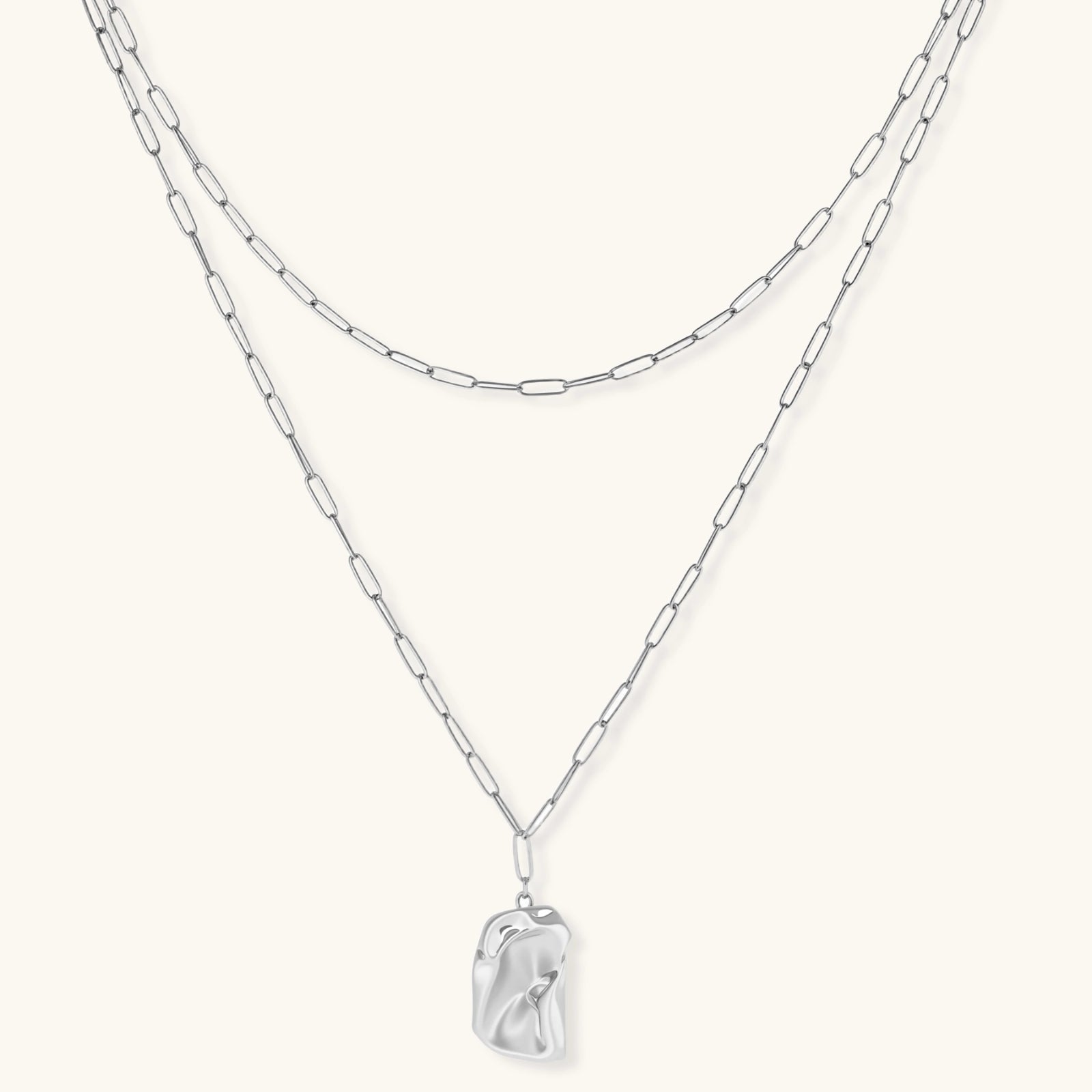 Layered paperclip chain necklace with organic flowing pendant made from eco-zinc alloy in warm gold finish